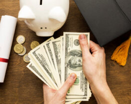 Flat Lay of Piggy Bank with Academic Cap and Banknotes