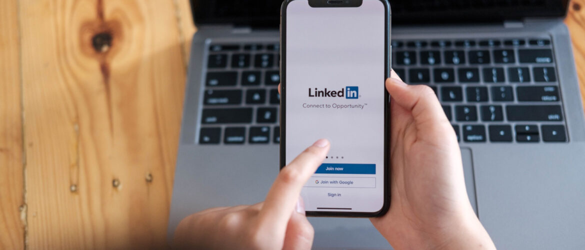 A women holds smartphone with LinkedIn application on the screen