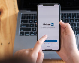 A women holds smartphone with LinkedIn application on the screen